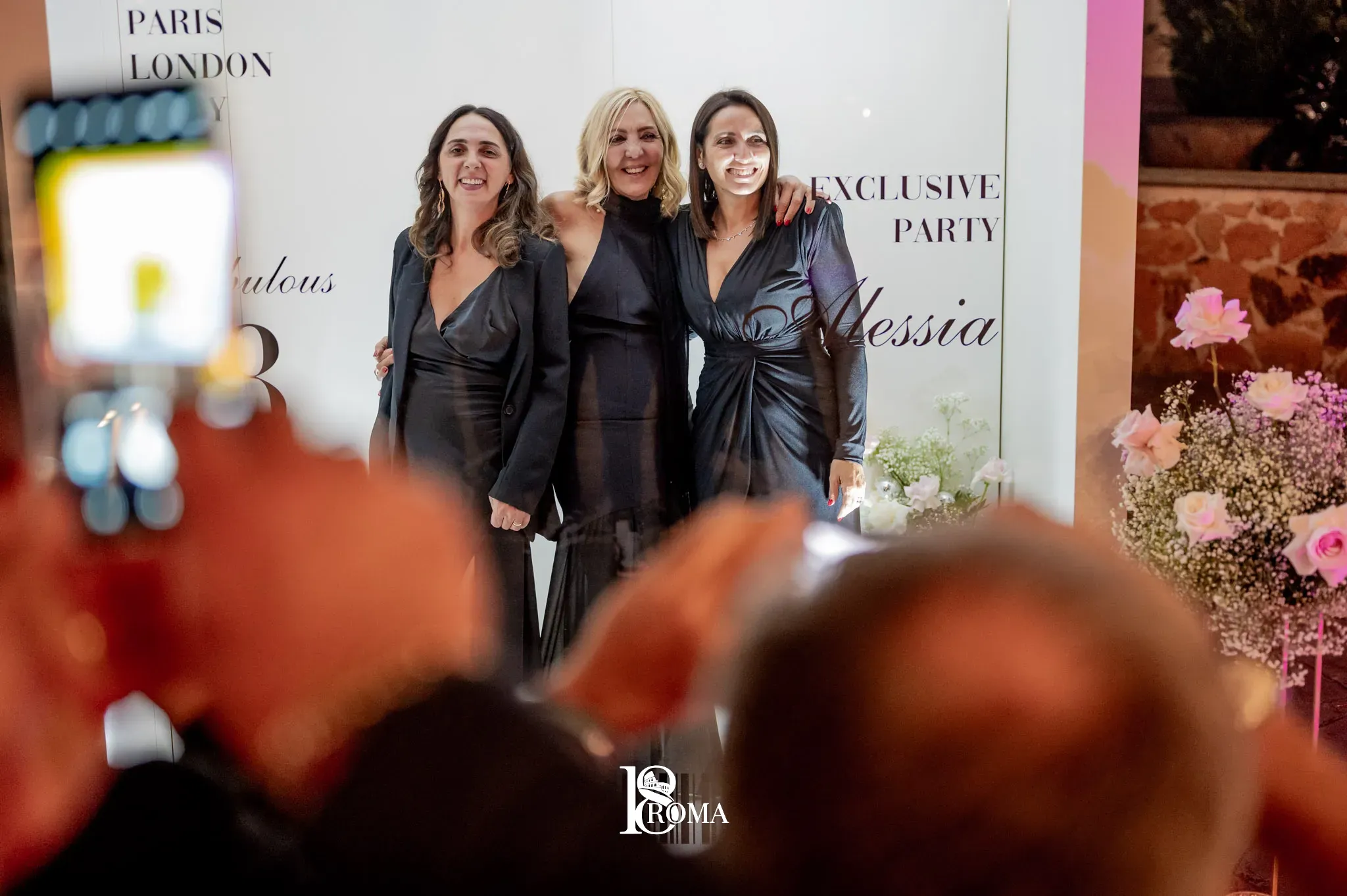 Ospiti fotografati davanti al pannello di un evento